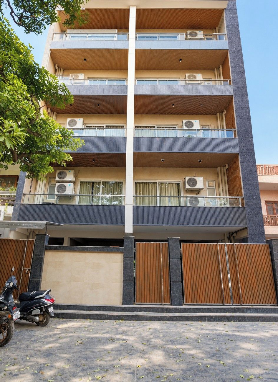A multi-story residential building with balconies, air conditioning units, and a gated entrance.