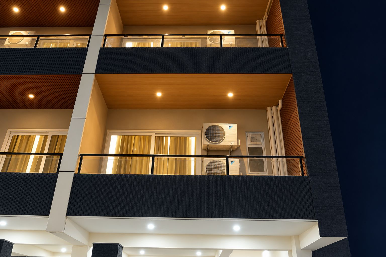 A multi-story building with balconies, air conditioning units, and a modern architectural design.