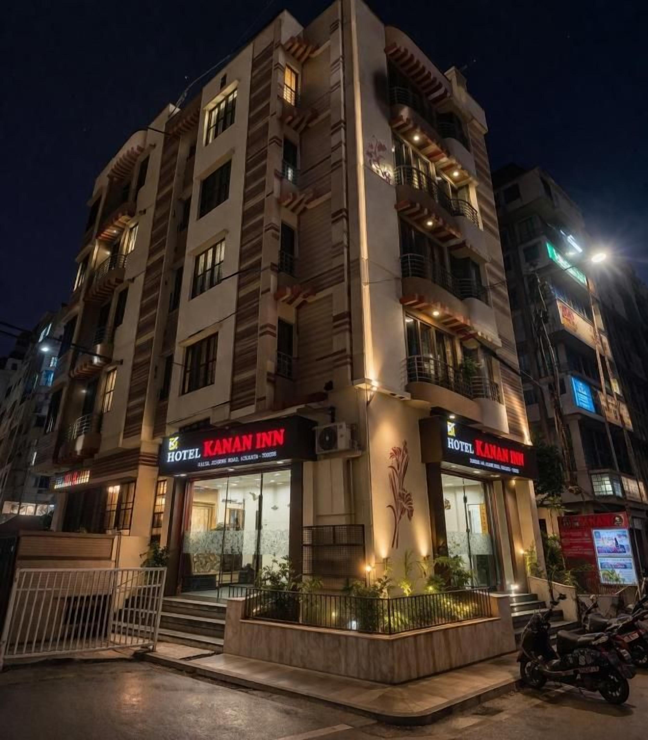 A multi-story hotel with a prominent sign for 'Hotel Kanan Inn' at night.