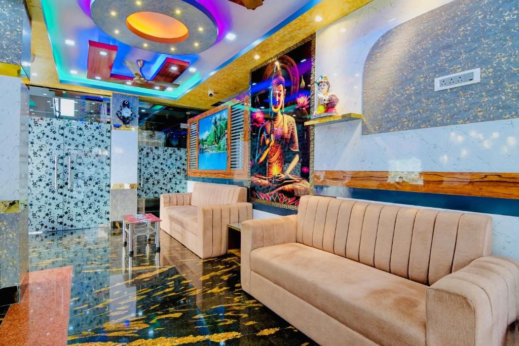 A lobby with a Buddha statue, plush seating, and a colorful ceiling.