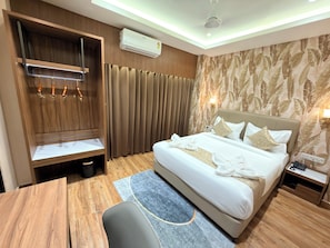 Una habitación de hotel con cama, escritorio, armario y baño.