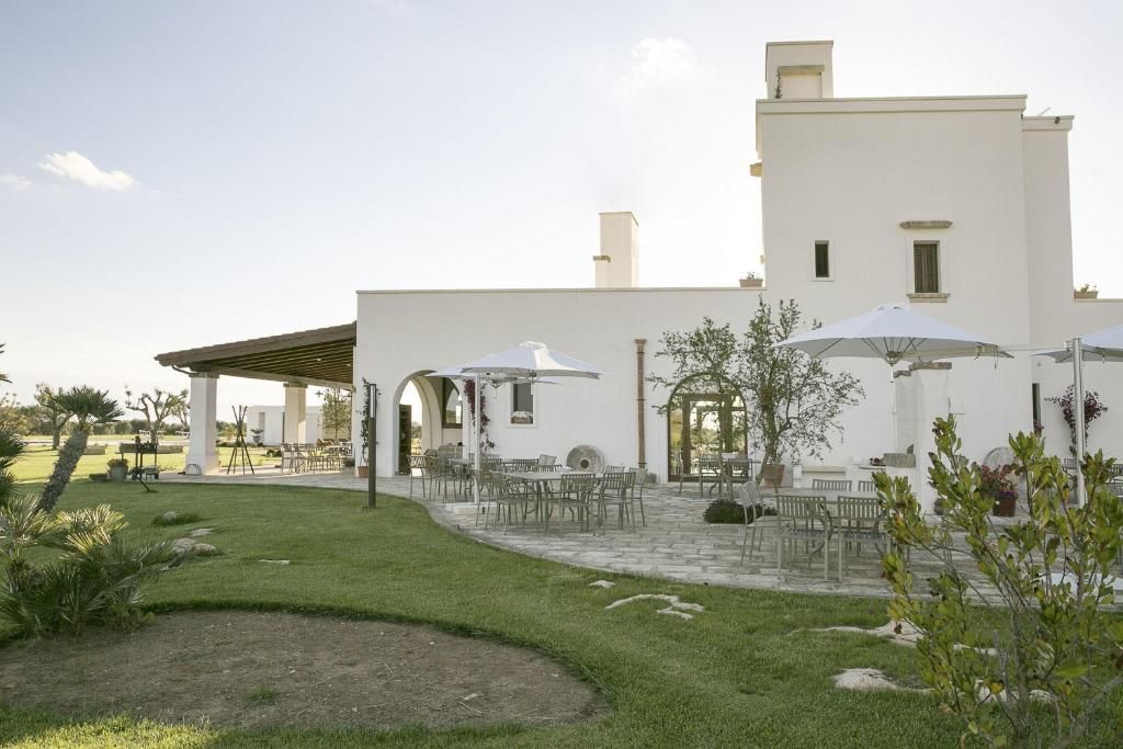 Un bâtiment blanc doté d’une terrasse extérieure et d’un patio couvert.