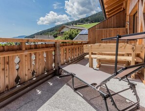 A wooden deck with a bench and a table, overlooking a mountainous landscape. - With 3 Bedrooms (Velturno)