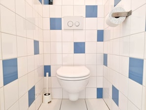 A bathroom with a toilet, a bidet, and a toilet paper holder. - Do36 Holiday Home With dog Domburg (Domburg)