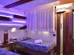 Ein Hotelzimmer mit Bett, Nachttisch mit Lampe und einem Vorhangfenster.