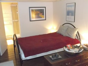 A bedroom with a bed, bedside tables, a nightstand, and a door leading to another room. - Holiday Apartment With 3 Bedrooms (Karlsborg)