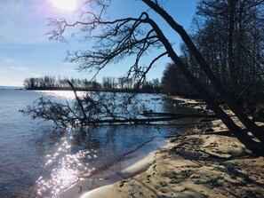 A beach with clear water, a sandy shore, and trees in the background. - Holiday Apartment With 3 Bedrooms (Karlsborg)