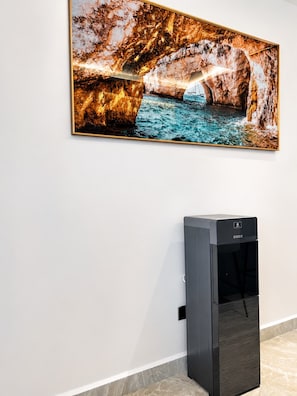 Ein an der Wand befestigtes Kunstwerk, das eine natürliche Szene mit Wasser und Felsformationen zeigt.