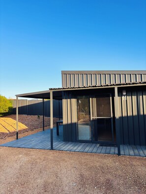 A modern building with a flat roof, large windows, and a covered outdoor area. - Red Earth Retreat - raw,natural timber home (Kalbarri)