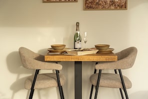 Una mesa de comedor con dos sillas, una botella y dos cuencos.