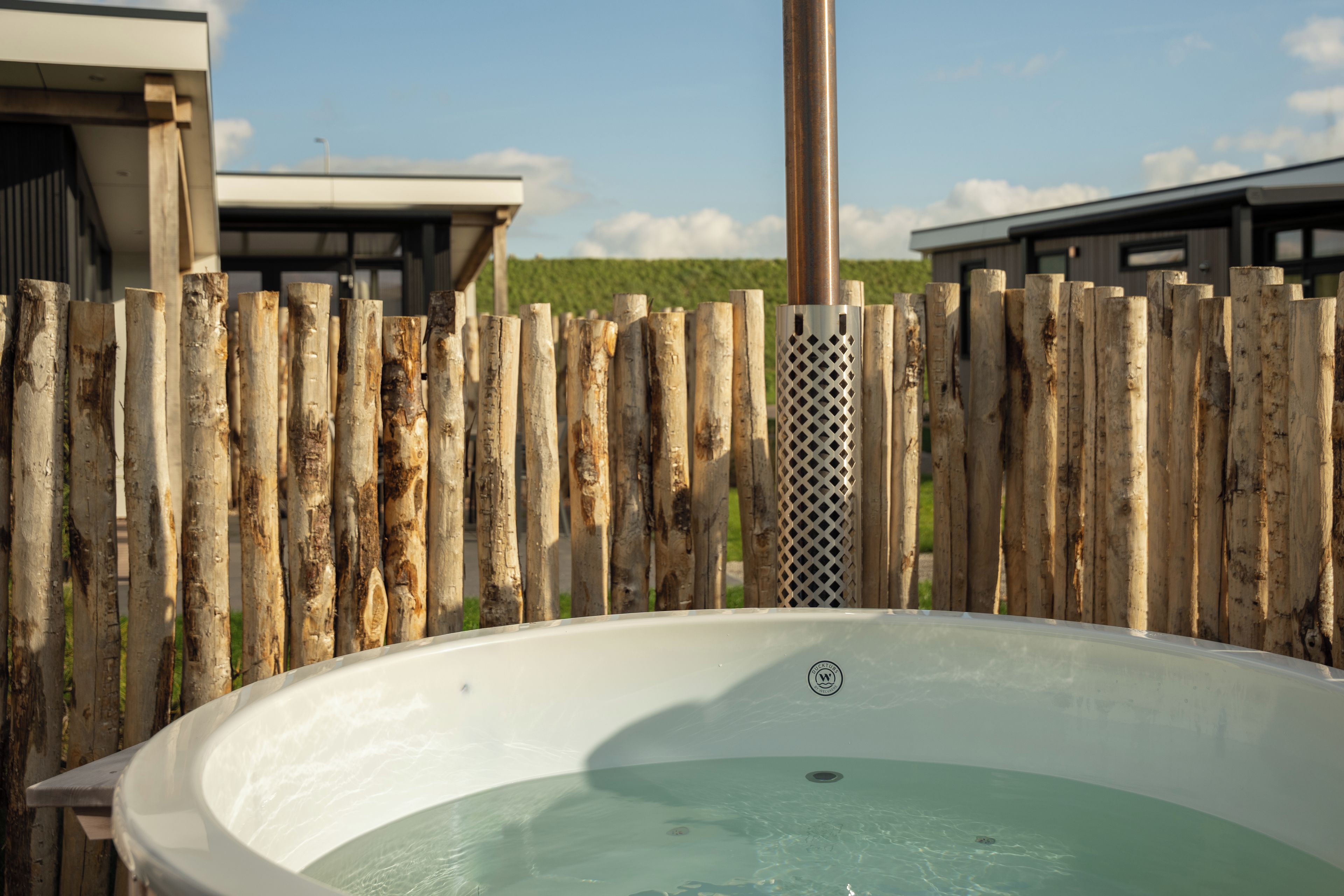 Un bain à remous avec une clôture en bois en arrière-plan.