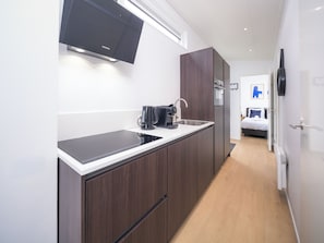 Eine moderne Küche mit Einbau-Mikrowelle, Kaffeemaschine und Kühlschrank.