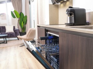 Una cucina moderna con lavastoviglie, macchina del caffè e una pianta.