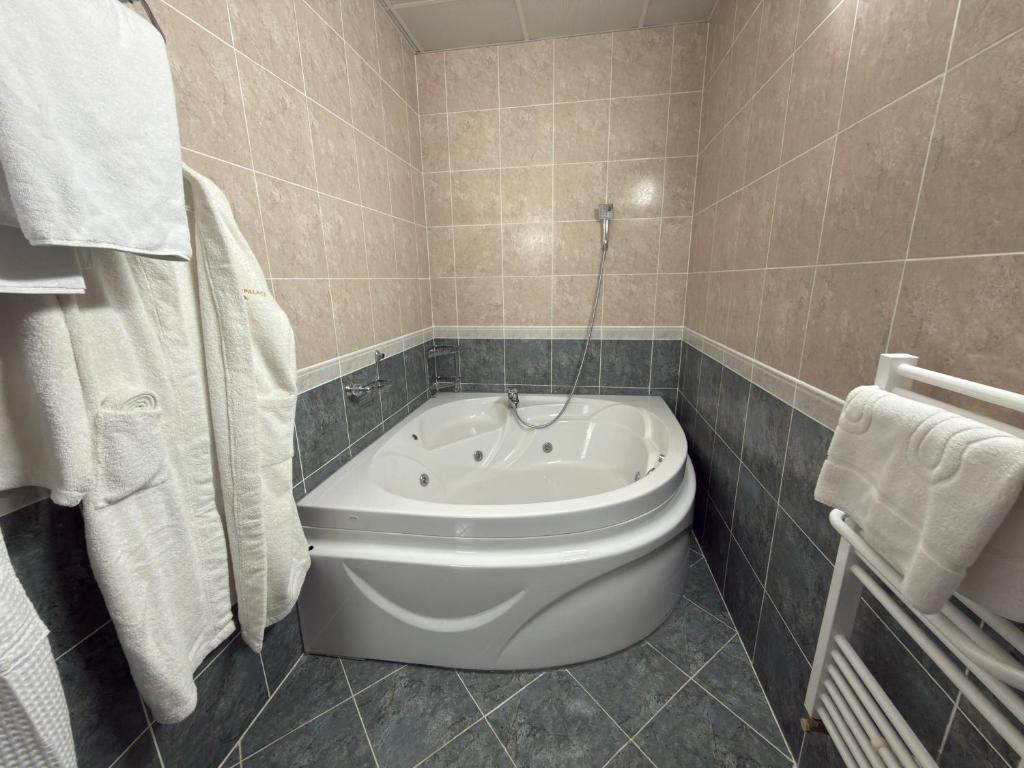 Un baño con bañera, ducha y un perchero para toallas.