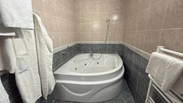 Un baño con bañera, ducha y un perchero para toallas.