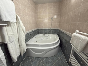 A bathroom with a bathtub, a shower, and a towel rack.