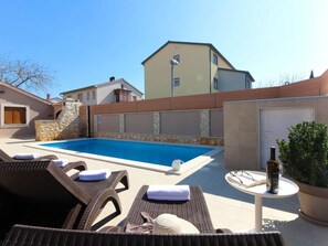 A swimming pool with lounge chairs and a table with a bottle. - Villa Magnifica With Private Pool in Pula (Pula)
