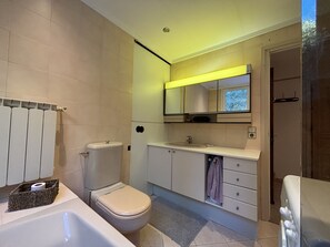 Une salle de bain moderne équipée de toilettes, d’un lavabo et d’une baignoire.