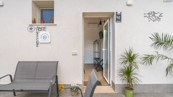Ein Hotel Eingangsbereich mit einer Rezeption, einer Sitzecke mit Sesseln und einer Zimmerpflanze.