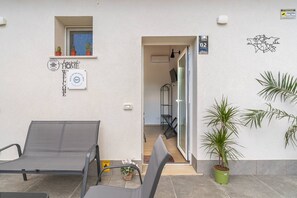 Ein Hotel Eingangsbereich mit einer Rezeption, einer Sitzecke mit Sesseln und einer Zimmerpflanze.