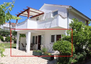 A two-story house with a covered patio area, outdoor seating, and a garden. - A5 - Comfortable apartment with terrace, garden and sea view (Barbat na Rabu)