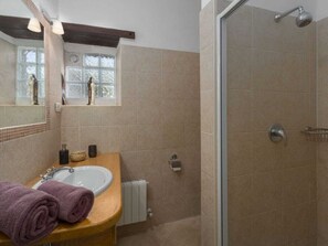 Ein Badezimmer mit Waschbecken, Spiegel und Dusche.