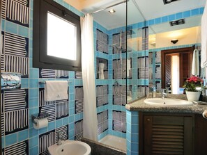A bathroom with a striped tile backsplash, a sink, a mirror, and a window. - L"ea di Lavru - Apt 4 (Loiri Porto San Paolo)
