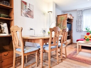 A dining area with a wooden table and chairs, a coffee machine, a plant, and a painting on the wall. - Do09 Holiday Home Domburg (Domburg)