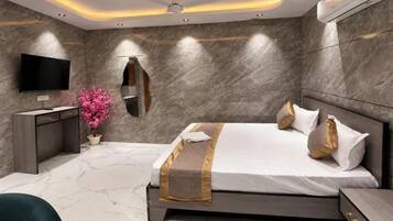A modern bedroom with a large bed, bedside tables, a TV, and a mirror.