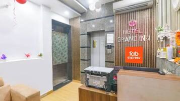 Zona de recepción de un hotel con un mostrador de madera, un fax y un cartel que dice 'HOTEL GRANTEIN INN'.