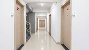 Un pasillo de hotel con puertas numeradas 209 y 206, una escalera y un suelo de baldosas impecable.