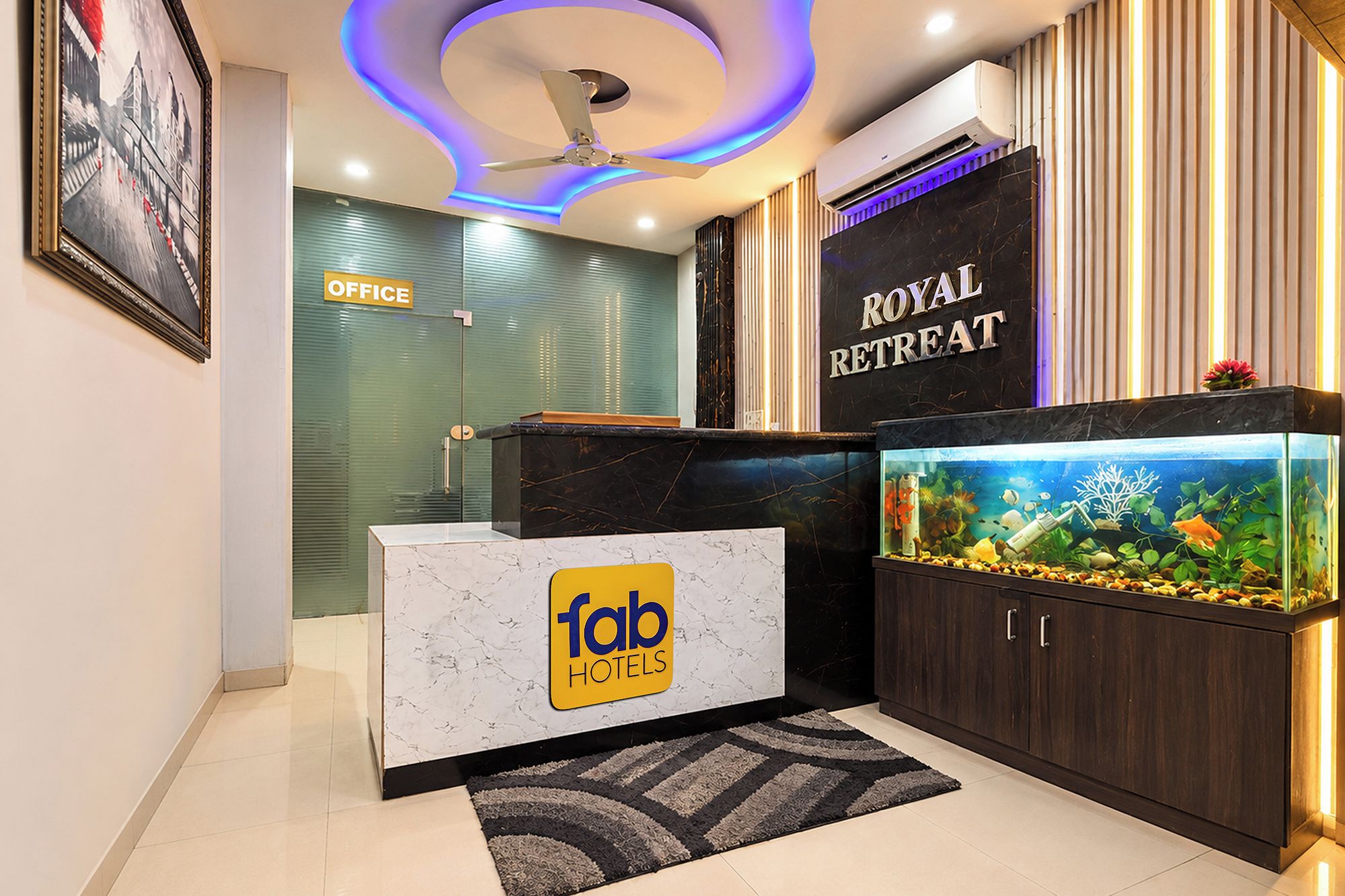A hotel reception area with a marble counter, a fish tank, and a sign for the Royal Retreat.
