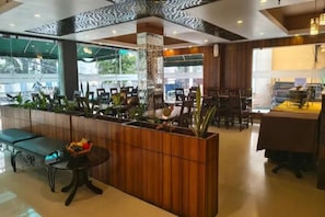 Un interior moderno con mostrador de recepción, zona de estar y comedor.