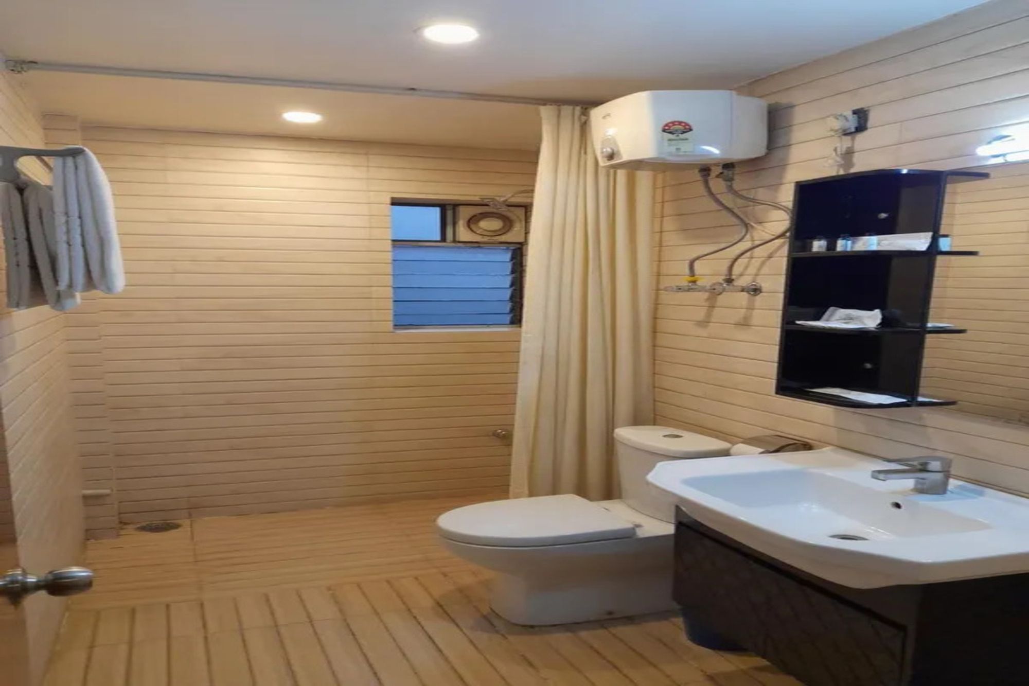 Une salle de bain comprenant des toilettes, un lavabo et un espace douche.
