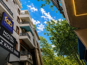 Un edificio de hotel con varios balcones y señalización para 'Tob Hotels', 'Hotel Mautz Inn' y 'Z Khas Inn'.