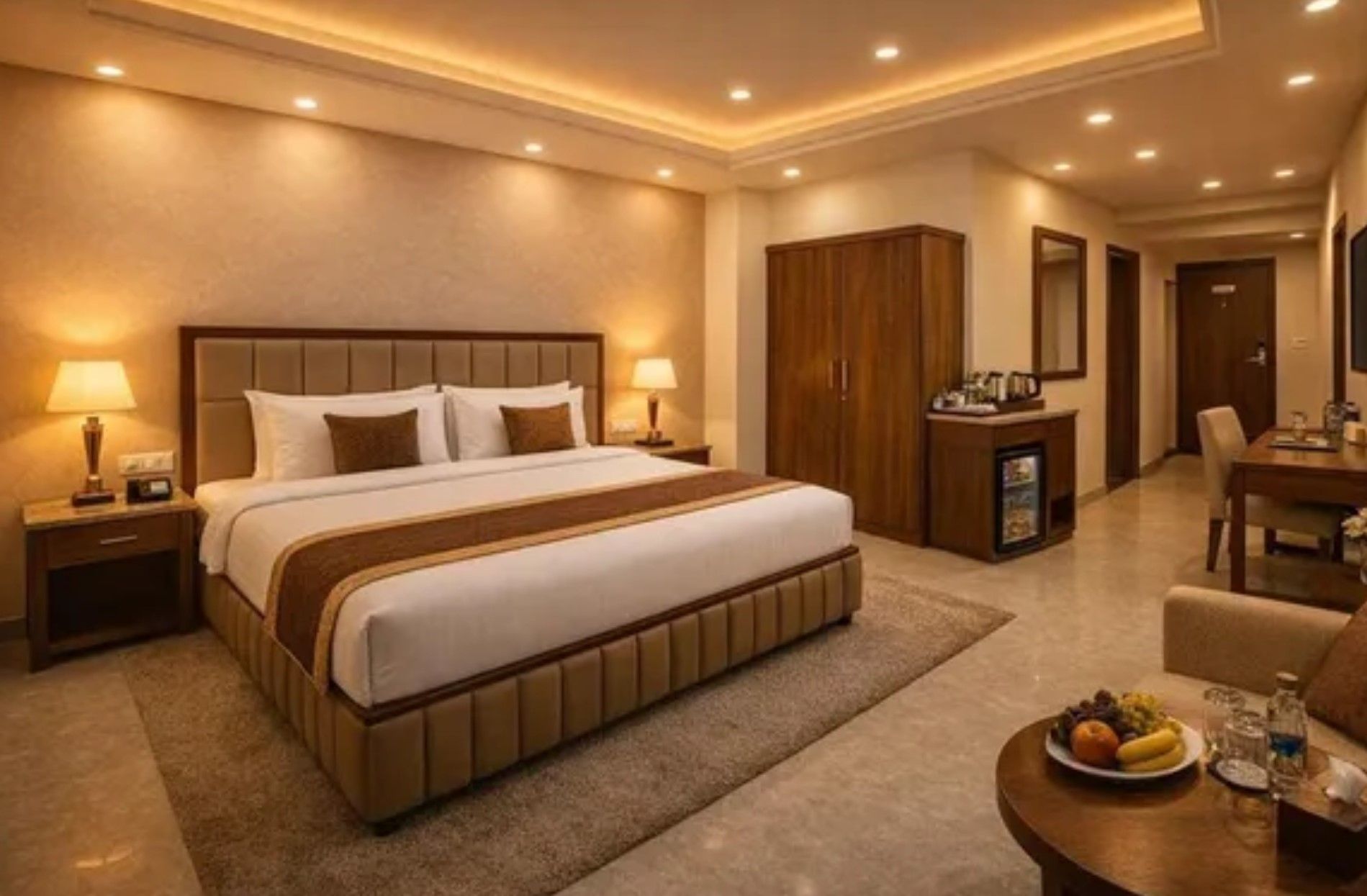 A hotel room with a large bed, bedside tables, a desk, and a dining area with a table set for two.