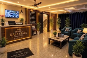 A hotel reception area with a reception desk, a television, and a seating area with sofas and a coffee table. - FabHotel Amazing Stays Ramesh Nagar (New Delhi)