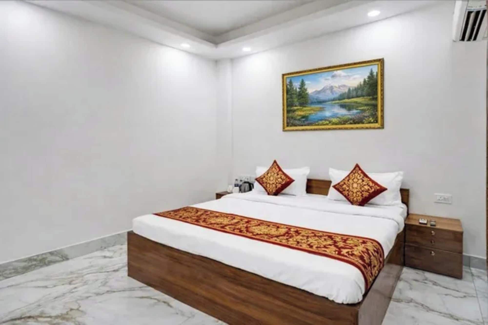 Una habitación de hotel con una cama de madera, ropa de cama blanca y un cuadro de un paisaje en la pared.