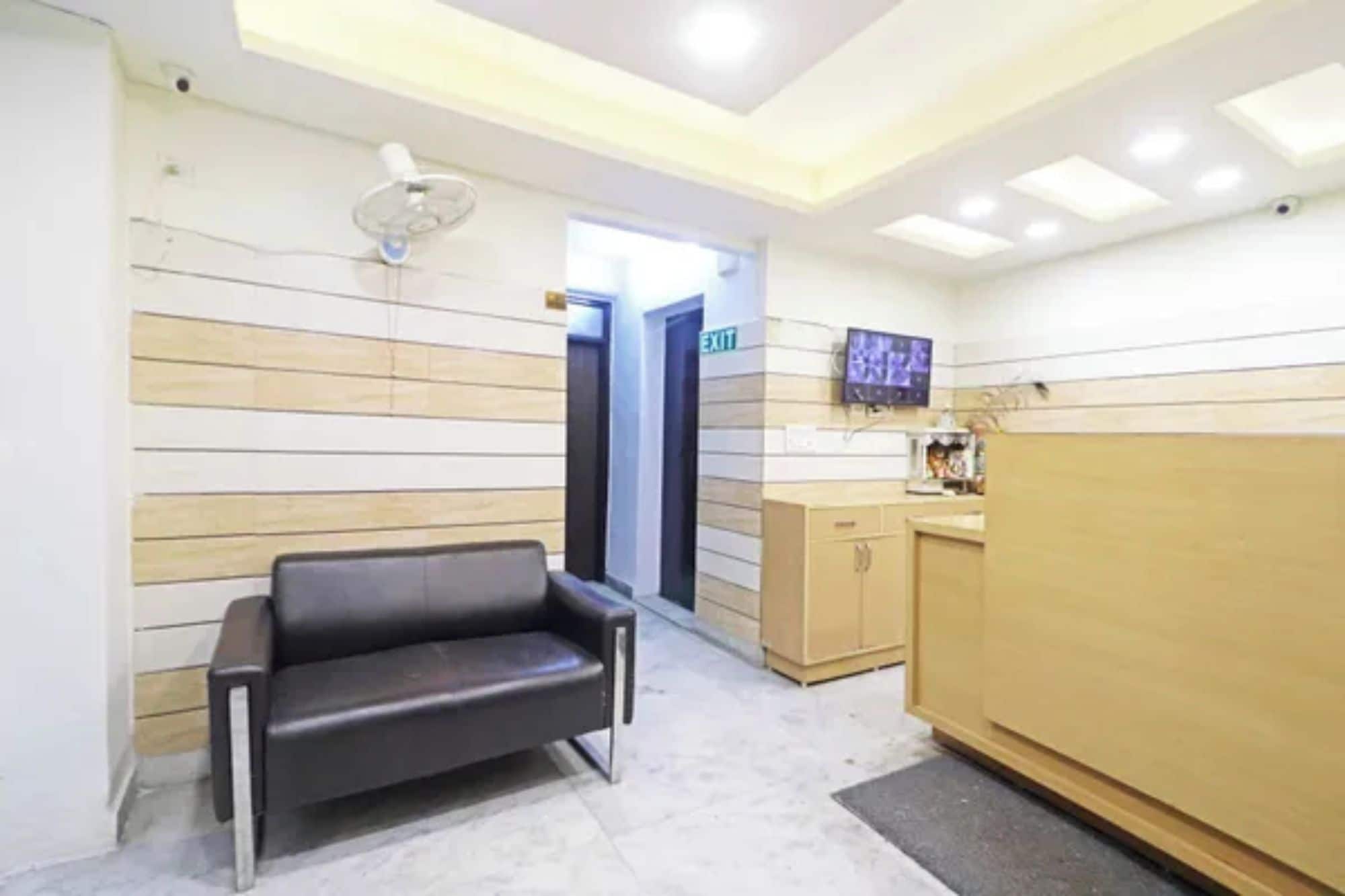 Una zona de recepción con un sofá, un aparador de madera y un televisor en la pared.