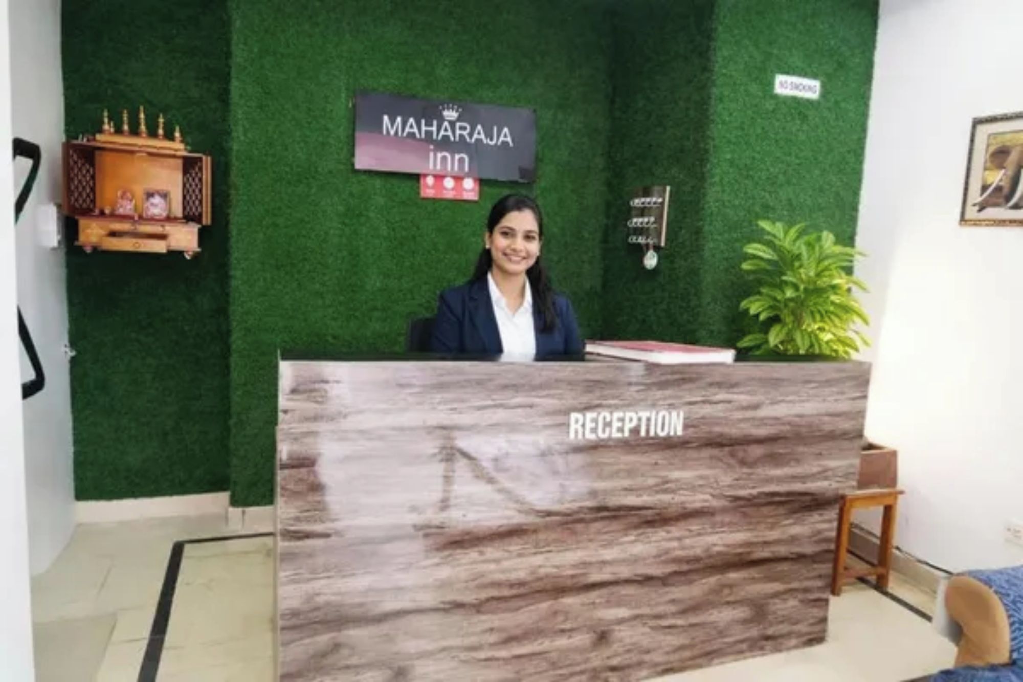 A reception desk with a sign reading 'MAHARAJA in' and a 'NO SMOKING' sign on the wall.