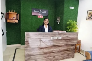 A reception desk with a sign reading 'MAHARAJA in' and a 'NO SMOKING' sign on the wall.