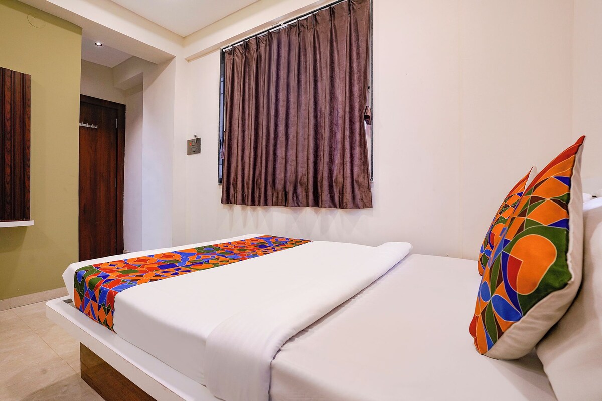 Una cama individual con un edredón colorido y una almohada con diseño geométrico.