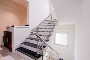 A staircase with a metal handrail and black steps.