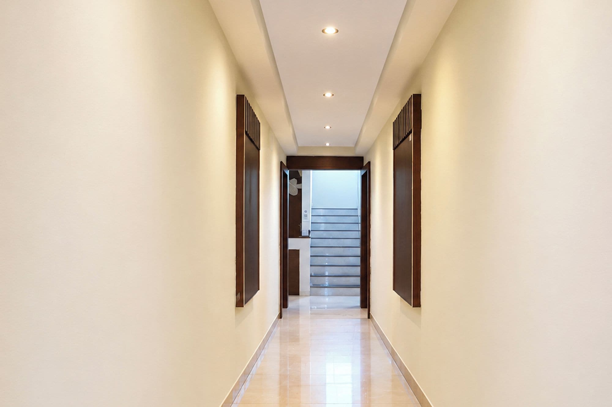 A hallway with a staircase leading to an upper floor.