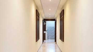 A hallway with a staircase leading to an upper floor.