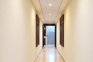 Un pasillo con una escalera que sube a un piso superior.