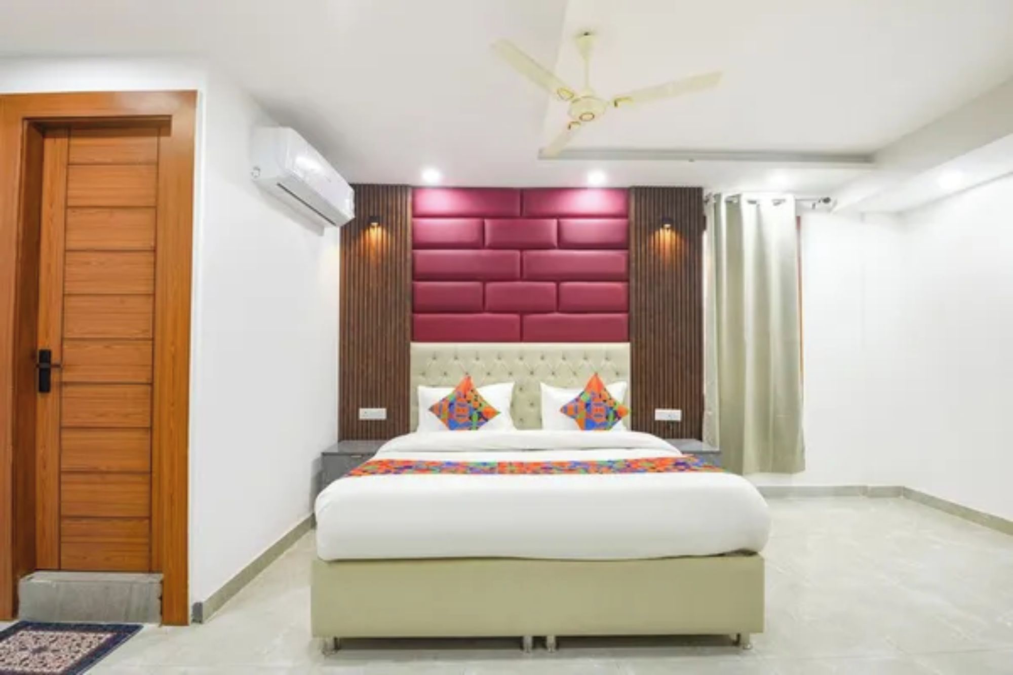 A bedroom with a bed, a ceiling fan, and a wooden door.