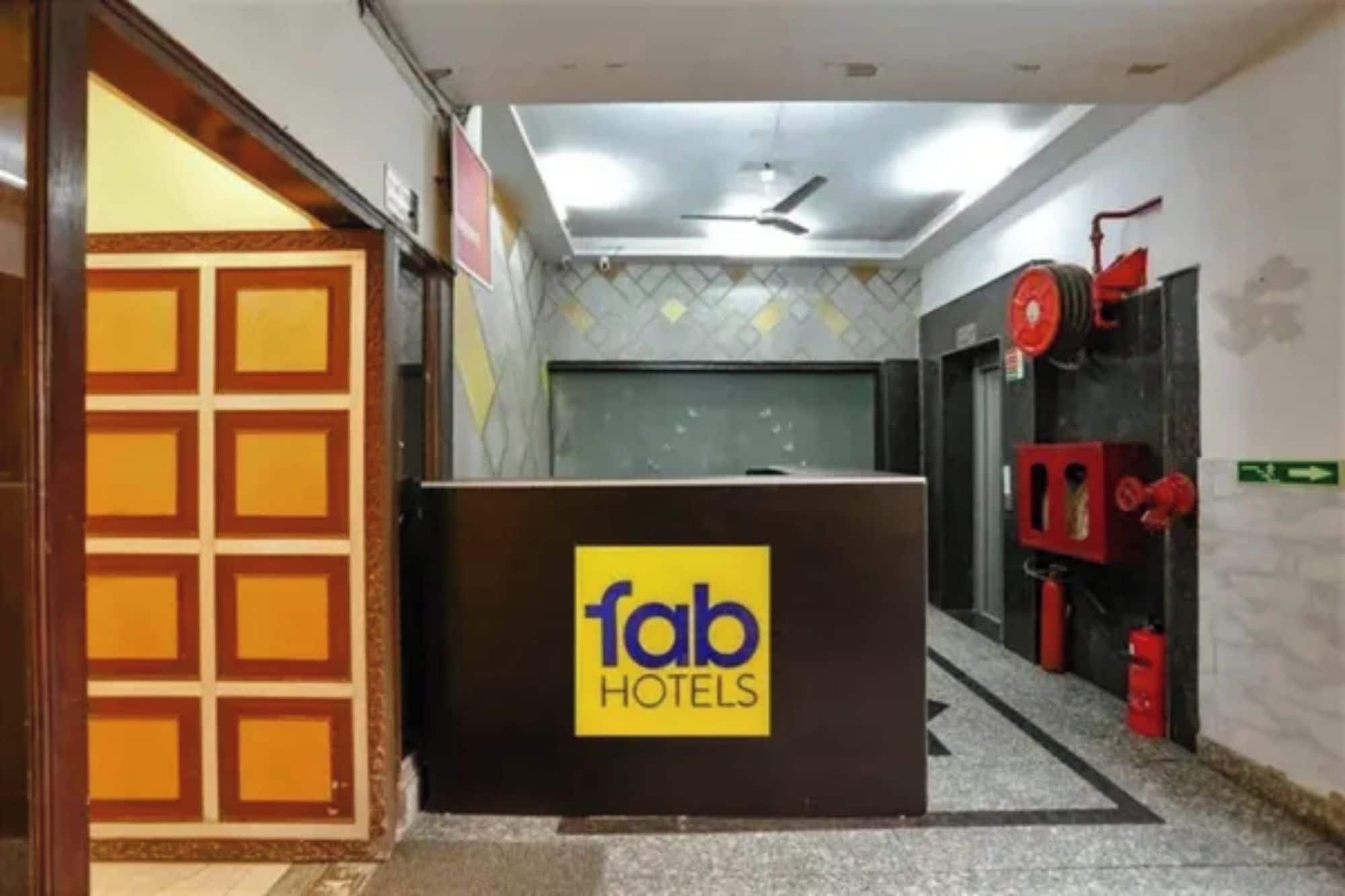 Un taulell de recepció amb el logotip de 'fab hotels' i un extintor fixat a la paret.