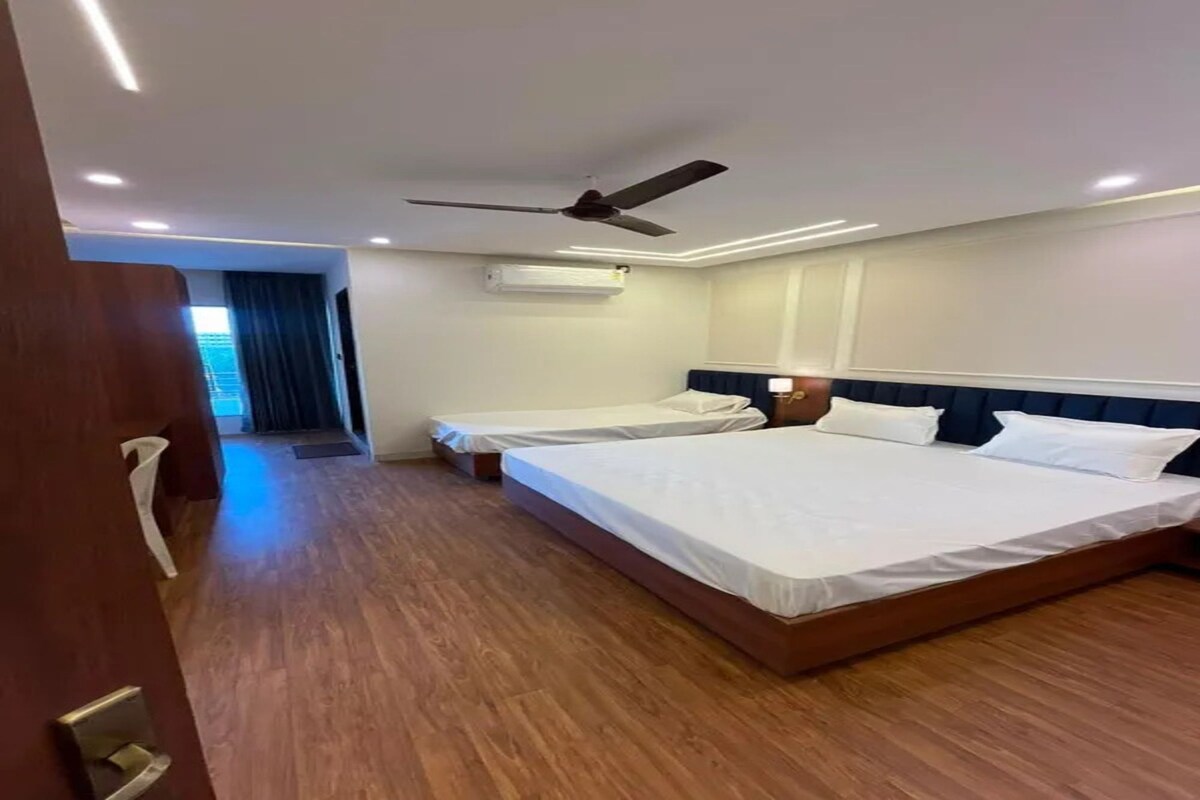 Habitación de hotel con dos camas, ventilador de techo y aire acondicionado.