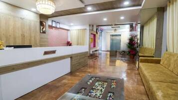 A reception area with a reception desk, a waiting area with a sofa, and a decorative glass coffee table.